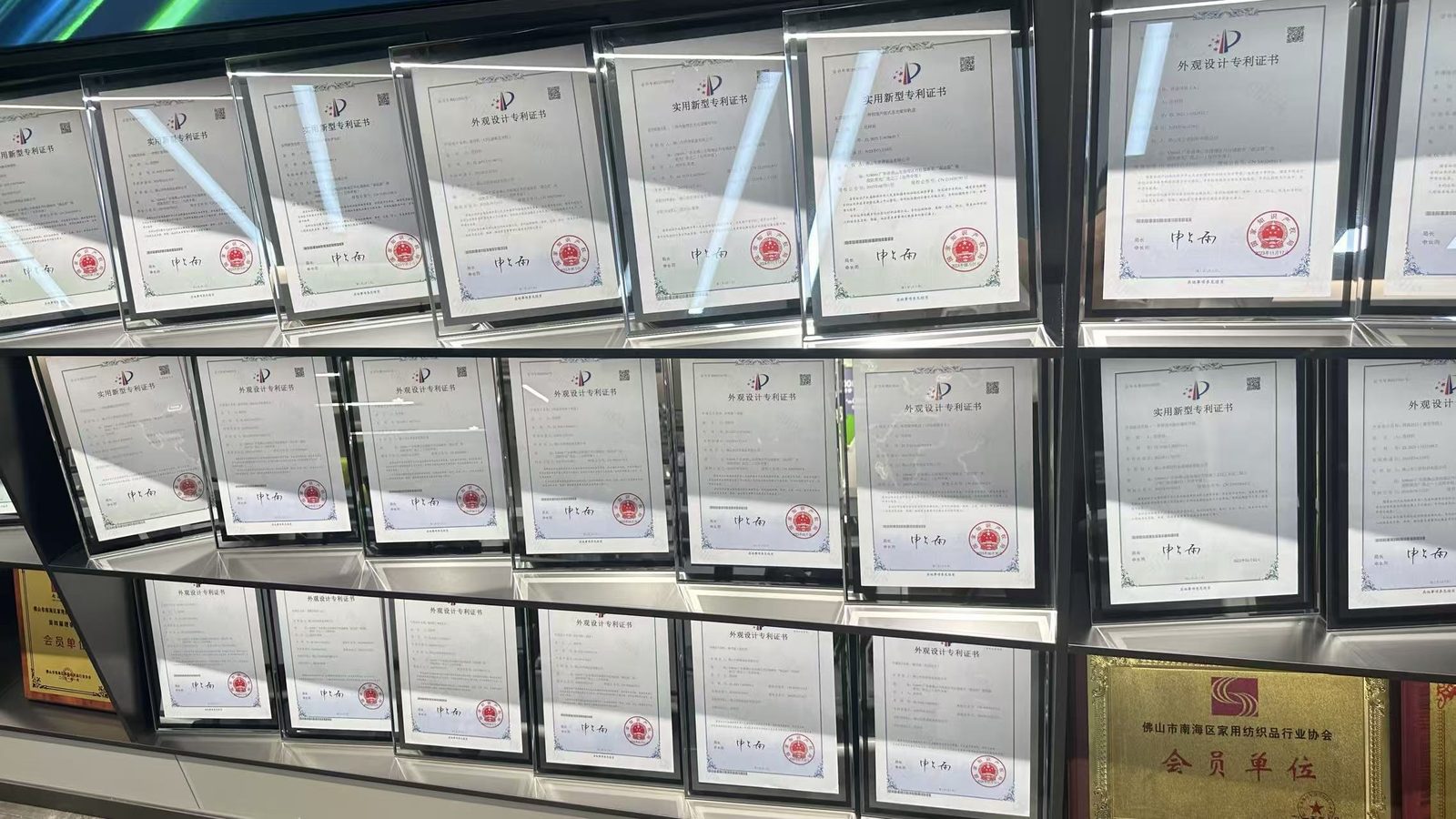 Framed invention, utility model and design patent certificates on the showroom patent wall