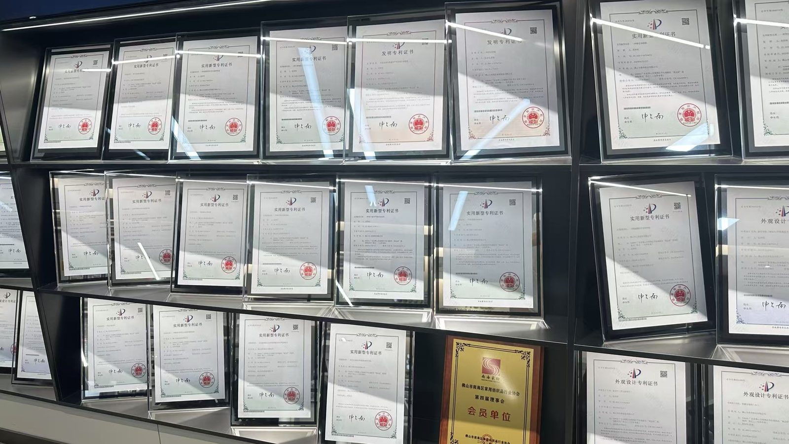 More framed patent certificates displayed on the showroom wall