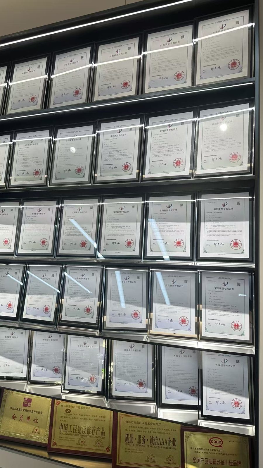 Tall shelves of framed patent certificates in the showroom